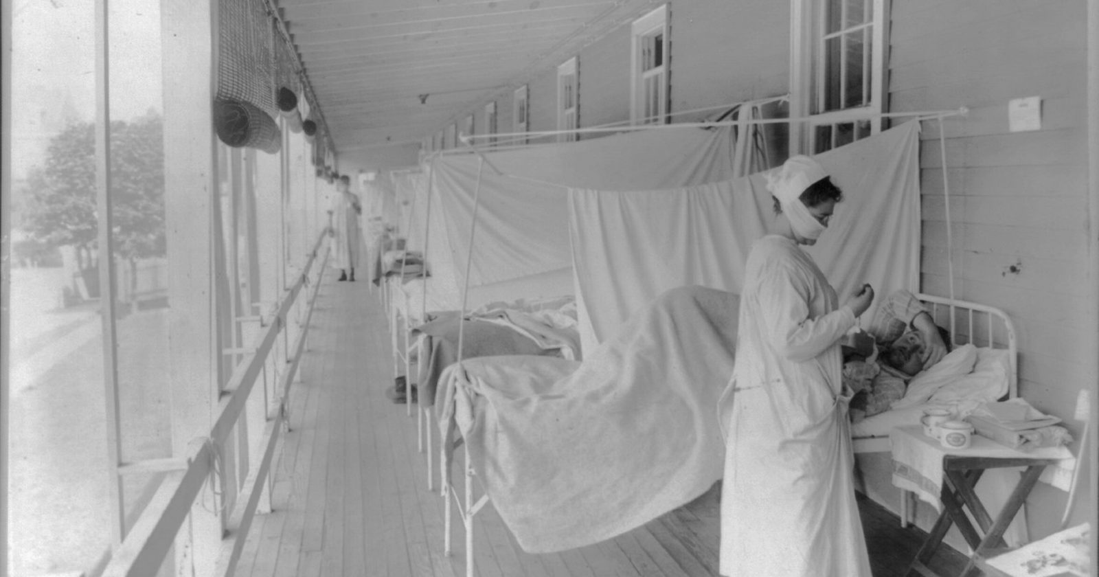 Pielęgniarka mierząca puls pacjentowi na sali szpitalnej — publiczna opieka nad chorym
